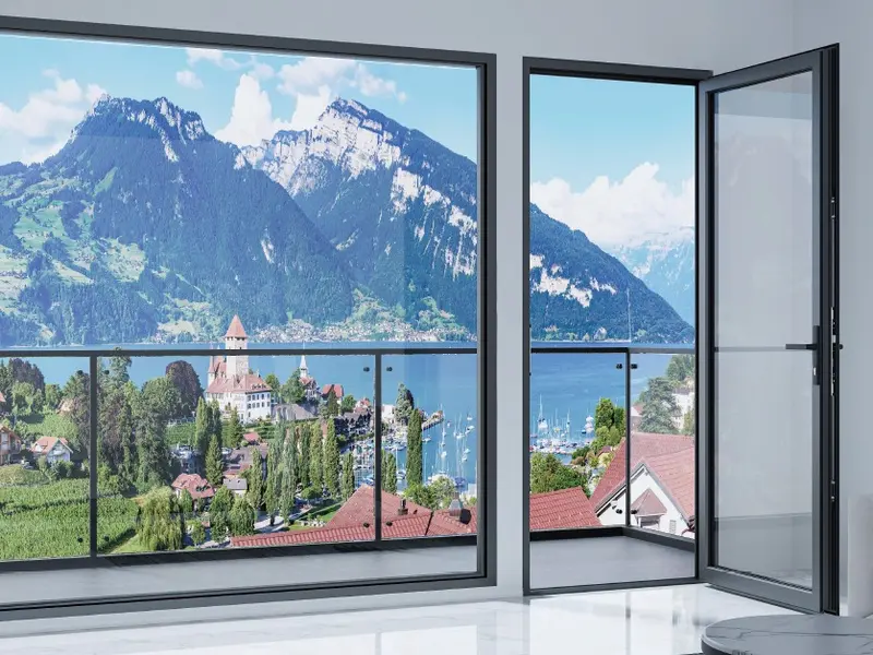 Aluminium swing door opened onto a balcony with a lake and mountain view