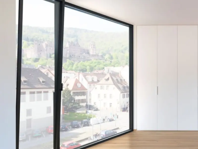Tilt and turn window/door wall in an empty room overlooking a hillside town
