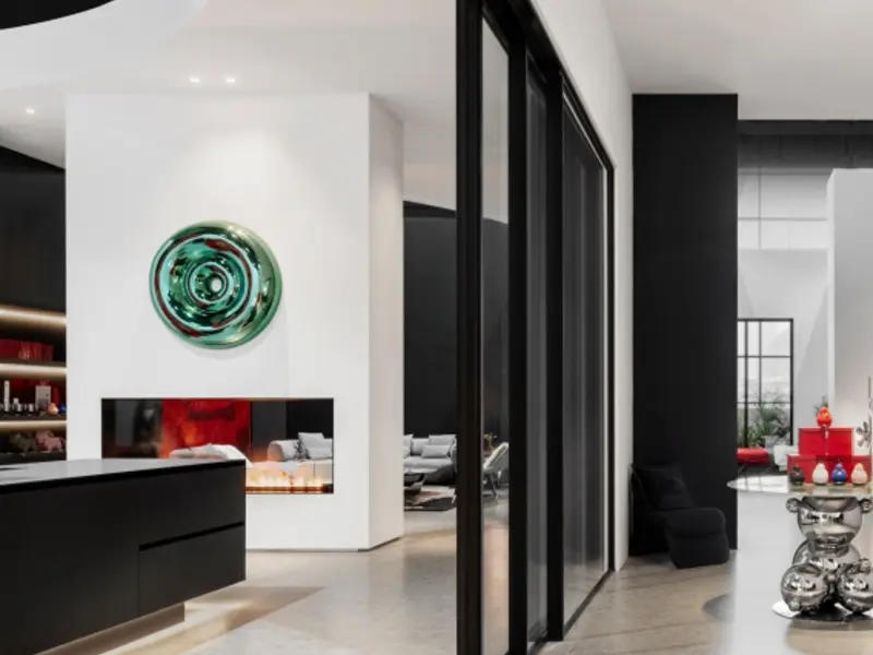 Black-framed invisible-frame sliding glass wall in a dark modern interior